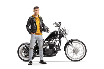 Young guy holding helmet and posing next to a custom motorbike