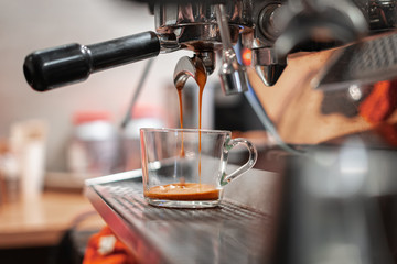 A professional coffee machine brews coffee in a glass Cup.