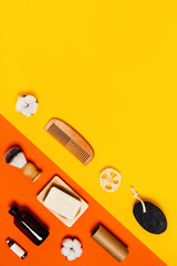 Ecological accessories for body care on two-toned yellow and orange background.