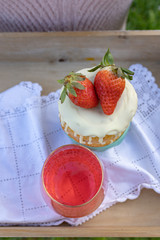 Wooden tray with strawberry cake and red drink