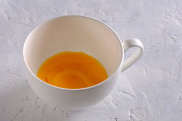 Egg yolks in a white cup closeup