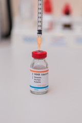 measles mumps and rubella vaccination concept with syringe in vaccine vial