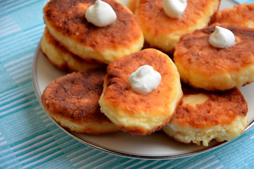 cottage cheese pancakes with cream on a plate closeup
