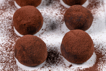Fine chocolate truffles on white ceramic plate.