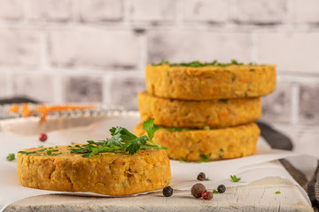 Raw veggie burger with chickpeas, vegetables and parsley leaves on kitchen countertop
