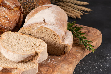 Fresh fragrant bread on the table. Food concept. Bakery, crusty loaves of bread and buns. Assortment of baked bread.