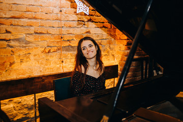 Funny girl playing the piano in a cozy restaurant