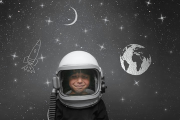 Small child wants to fly an in space wearing an astronaut helmet