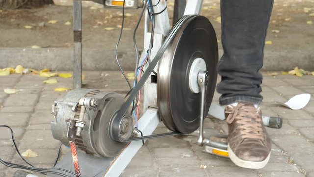 Student pedals on bicycle and generates electrical energy. Concept of engineering, science, technology for DIY innovation