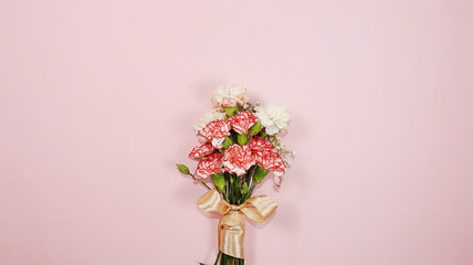 Carnations on a pink table, abstract spring floral background. Creative modern bouquet, minimal holiday concept. Greeting card for Women's Day or Mother's Day, happy birthday, wedding,