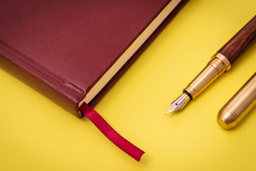 Stylish office still life on yellow table with pen and notepad