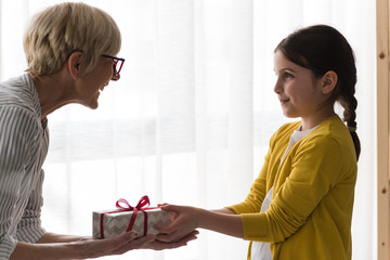 Granddaughter gives a gift to her grandmother