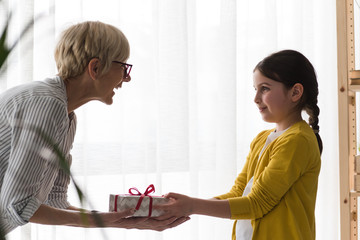 Granddaughter gives a gift to her grandmother