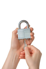  These are the hands of a young man inserting a key into an original padlock