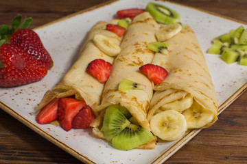Healthy crepes with fruits, banana, kiwi and strawberry. Healthy french breakfast