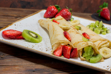 Healthy crepes with fruits, banana, kiwi and strawberry. Healthy french breakfast