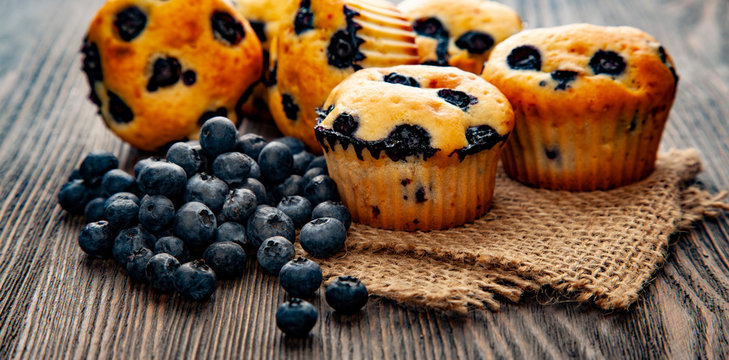 muffin with blueberries on a wooden table. fresh berries and sweet pastries on the board.