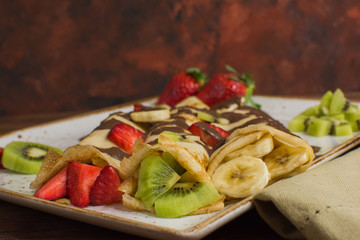 Healthy crepes with fruits, banana, kiwi and strawberry. Healthy french breakfast