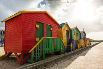 Colorful beach huts on the beach with backlight by the sun in Muizenberg, South, Africa