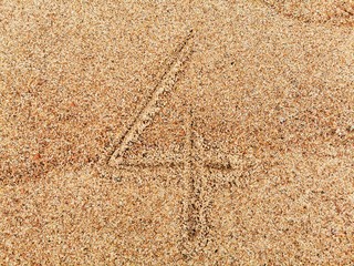 The number 4 on wet beach sand. 