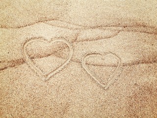 Two hearts painted on wet sand. Love concept. 