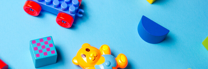 Colorful kids toys frame on wooden background. Top view. Flat lay. Copy space for text.