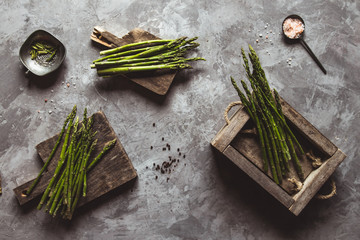 Asparagus on a cutting board in a wooden box. Healthy food, health on a concrete background.