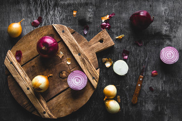 Red Onion Slices on wooden board with dark background