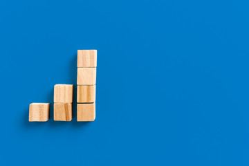 Growth bar chart, Graph diagram made with wooden block isolated on blue background and space for text. Business strategy, sales and marketing concept.