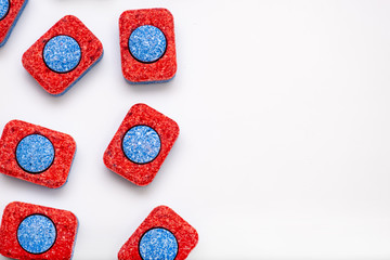 Many red and blue dishwasher soap tablets on white background, kitchen equipment and solutions for washing dishes, copy space - Powered by Adobe