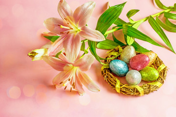Fototapeta na wymiar Easter lilies. Pink easter background with flowers lilies and colored easter eggs.Copy space, top view.
