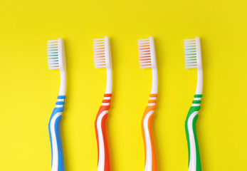 Toothbrushes for all family on a yellow background. Dental concept.
