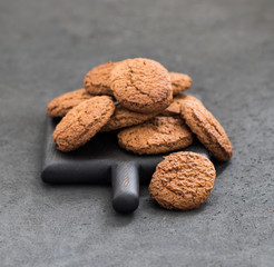Oatmeal cookies scattered on a dark gray background