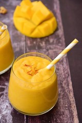 Mango Lassi, Indian popular summer drink served in glass garnish with saffron