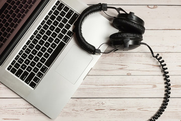 Notebook mockup and office wooden desk with notebook, headphone and plant. Desk mock-up and top view minimalist design.