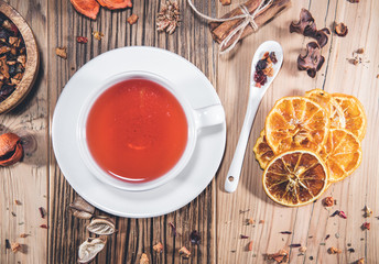 Cup of fruit tea with dry orange and cinnamon on wooden table