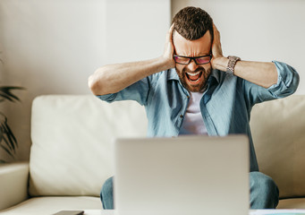 unhappy tired business  man in stress   at home office working on computer.