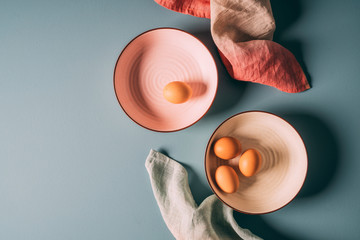 Overhead still life shot of farm fresh eggs on pastel plates with ombre napkins