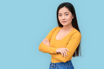 Young adult asian girl standing isolated on grey background