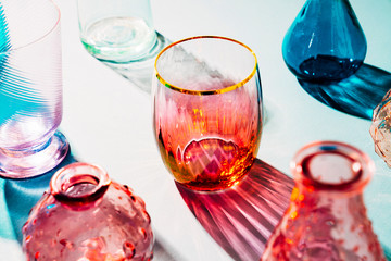 Various colored glasses brightly lit showing reflections and shadows