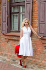 woman in white dress with a red Cape in his hands