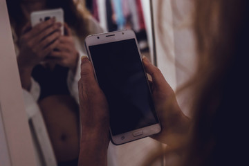 sexy girl with lingerie and mobile phone or smartphone in the room