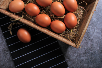 Eggs against black striped kitchen towel on dark background. Copy space. Concept of Easter.