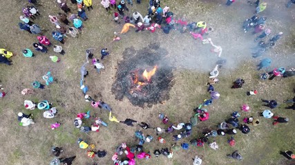 Children and adults dance around the bonfire at the Shrovetide festival.
