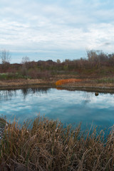 Small lake surrounded by vegetation in autumn colors. Shoot while searching for fishing grounds.