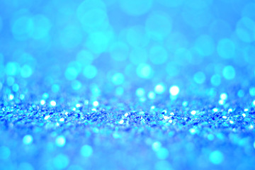 Obraz premium Lights on blue defocus background. Bokeh defocus disco effect. Holiday abstract background christmas lights garland. Winter festive shine sparkle glitter macro concept in blue color