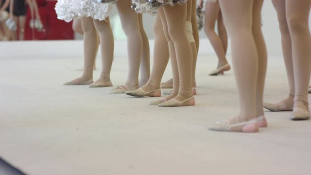 Low-section shot of legs of teen and preteen girls with pom-poms. School cheerleading team