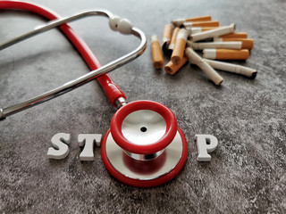 Smoked cigarettes and stethoscope on black background. Stop smoking concept. World No Tobacco Day.
