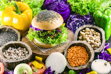 roasted vegan hamburger, made of vegetables and proteins. Healthy and vegetarian life concept. Colorful food, peppers, red cabbage, tomatoes, onions, chickpeas, soy, lettuce and lye - obrazy, fototapety, plakaty