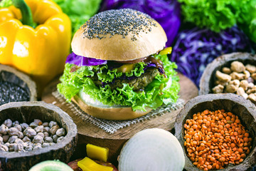 roasted vegan hamburger, made of vegetables and proteins. Healthy and vegetarian life concept. Colorful food, peppers, red cabbage, tomatoes, onions, chickpeas, soy, lettuce and lye